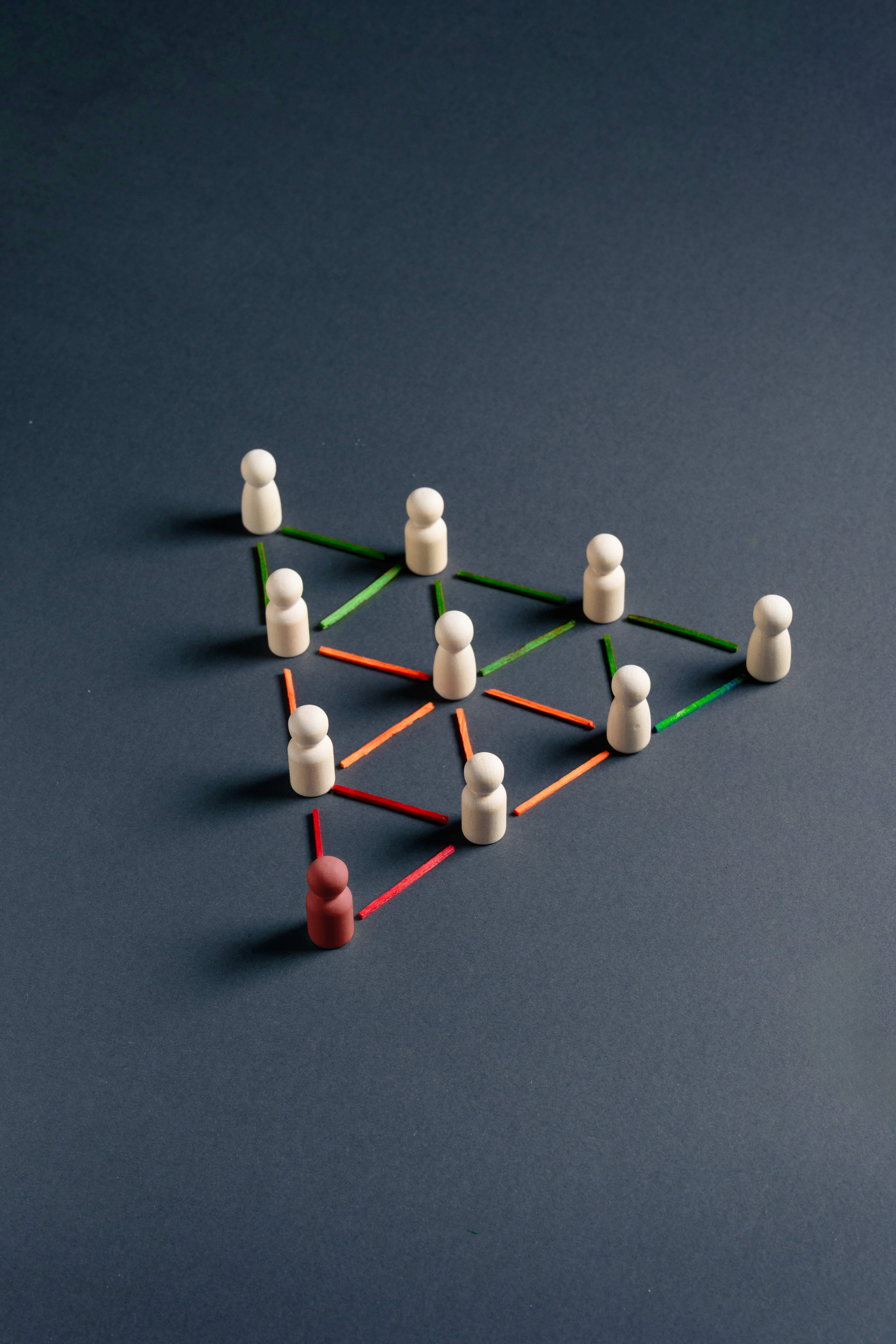 Wooden figures connected by colored lines, one in red